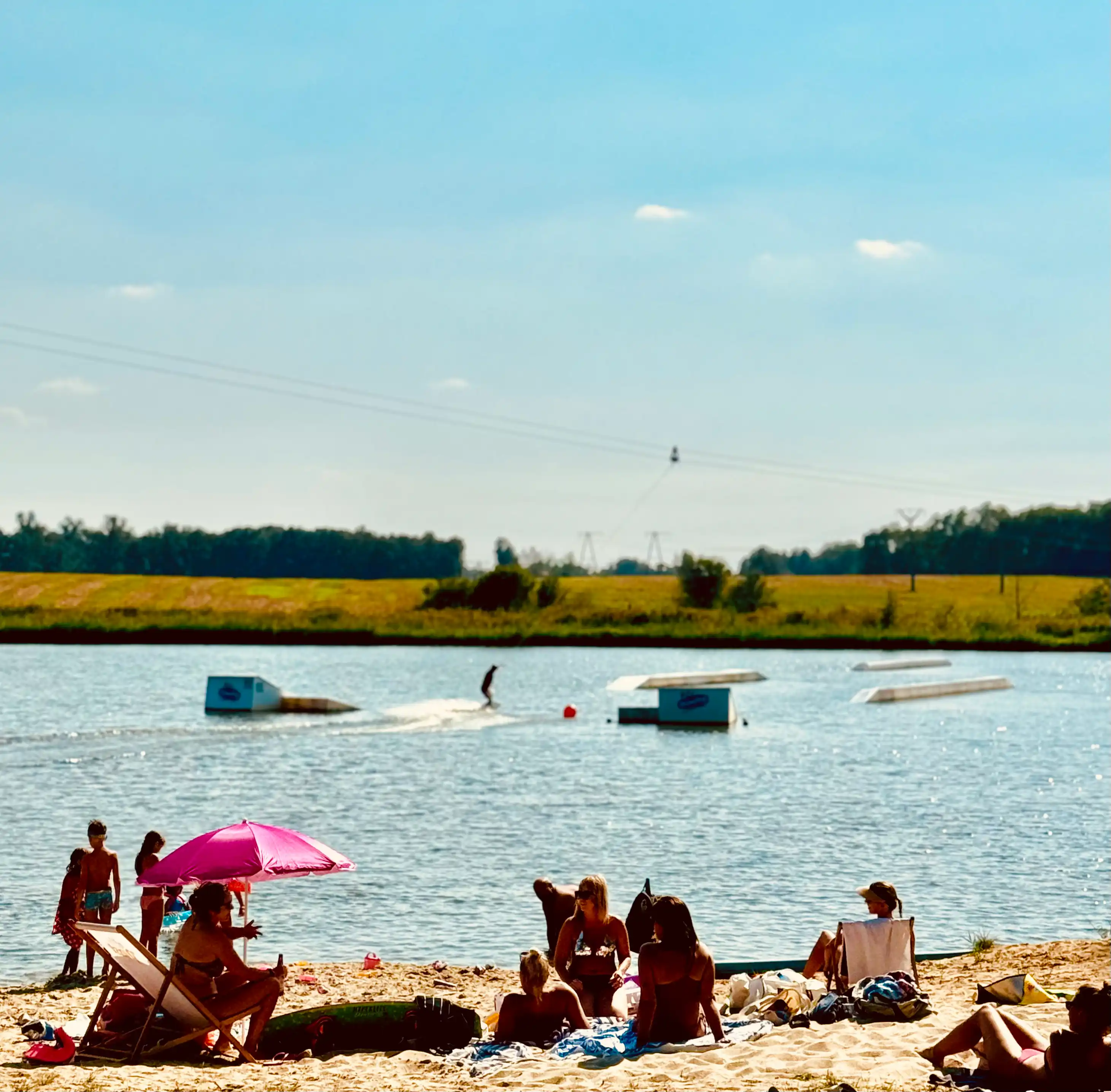 Piaszczysta plaża z leżakami i parasolami nad wodą